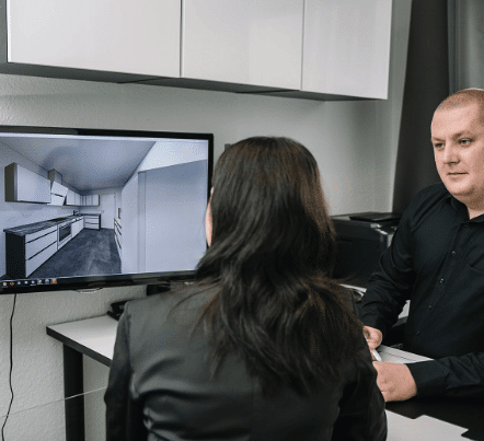 Küchenberater und Kundin bei der 3D-Küchenplanung am Bildschirm