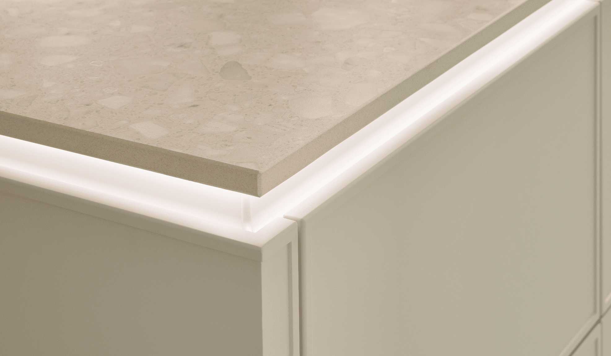 Keramik-Arbeitsplatte in hellem Cremeton mit LED-Kantenbeleuchtung und weißer Küchenfront
