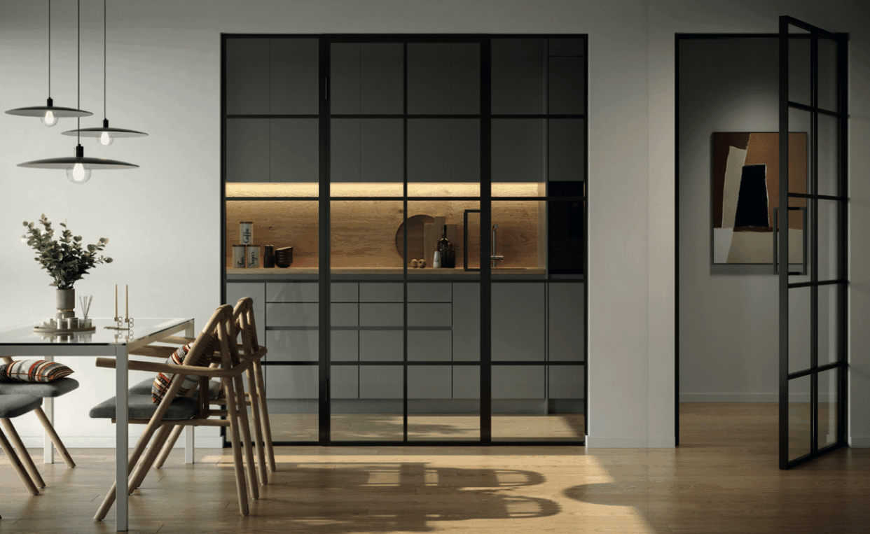 Lofttür aus Stahl und Glas als Raumteiler neben moderner heller Küche