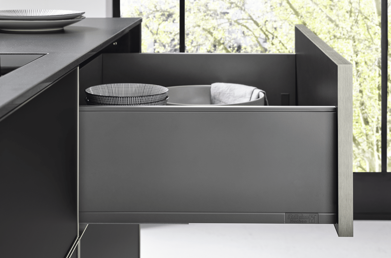 Dunkle Küche mit mehreren geöffneten Schubladen und Geschirr